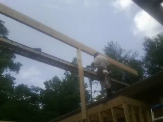 Carpenter setting a ridge beam over a new addition frame — Ice Dam Removal by Roofing Brothers in Thomaston