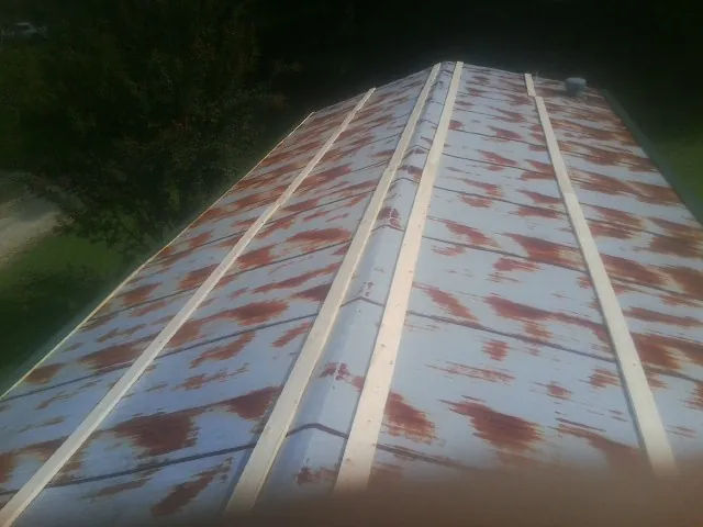 Rusted metal roof panels with new wood purlins before replacement — Storm Damage Roof Repair in Thomaston by Roofing Brothers